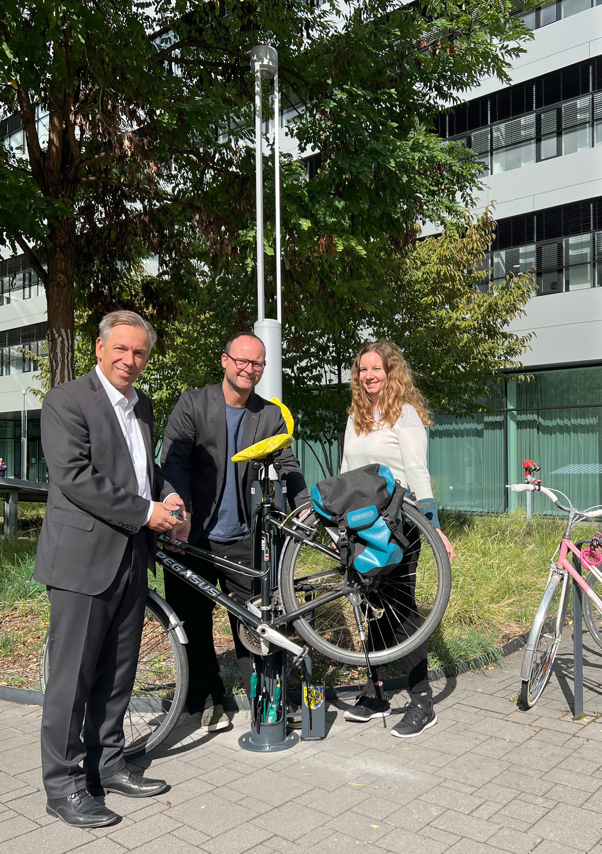 Landrat Alexander Tritthart (links), Radverkehrsbeauftragter Michael Förster (Mitte) und Klimaschutzmanagerin Luisa Pscherer (rechts) bei der Inbetriebnahme der neuen Fahrrad-Reparaturstation am Landratsamt.
