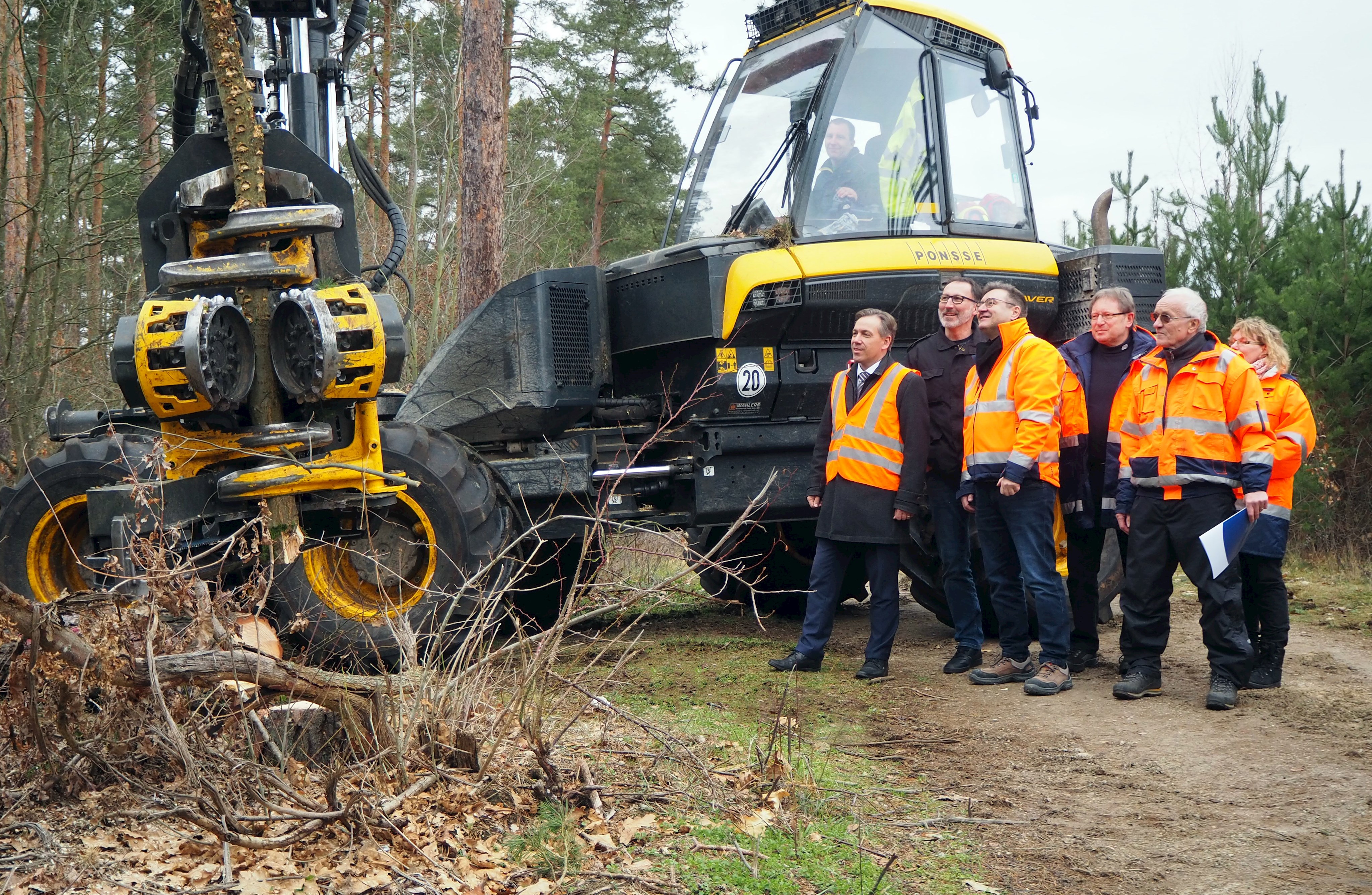 Bei den Vorarbeiten für den Geh- und Radweg entlang der ERH 33 verfolgt Geh- und Radwegexperte Bernhard Richter (2.v.r.) die Baumfällarbeiten mit einem Harvester aufmerksam. Dieses Projekt begleitete er von Anfang an. Er verabschiedet sich noch während der Maßnahme in den Ruhestand. Mit auf dem Bild: Landrat Alexander Tritthart, Stellvertretender Tiefbau-Sachgebietsleiter Oliver Jäger, Kreisbaumeister Thomas Lux, Tiefbau-Sachgebietsleiter Dieter Mußack und Richters Nachfolgerin Sigrid Tremel.