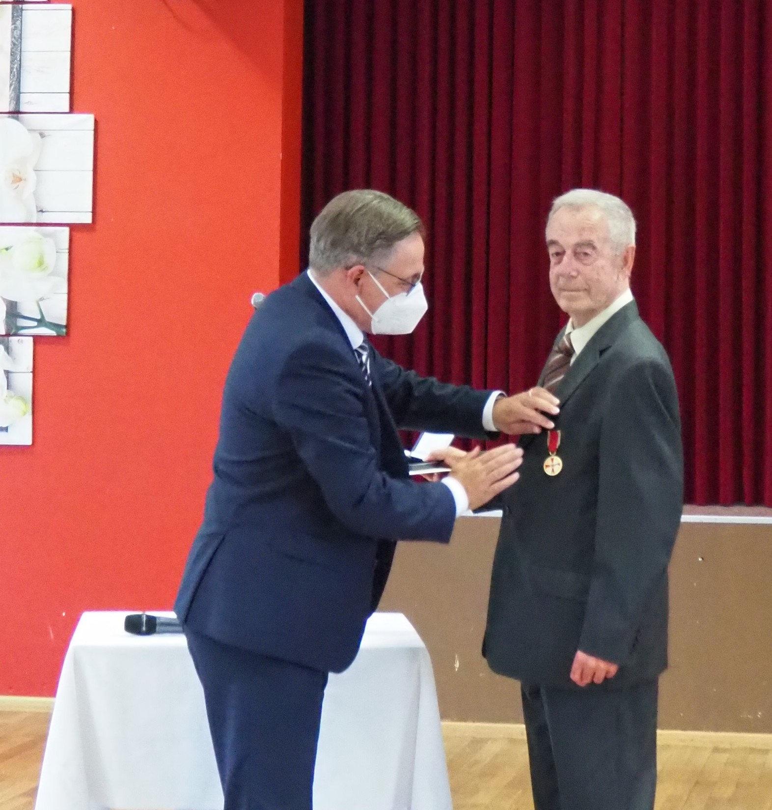 Ausgezeichnetes Ehrenamt: Landrat Alexander Tritthart steckt Johann Müller die Verdienstmedaille an.