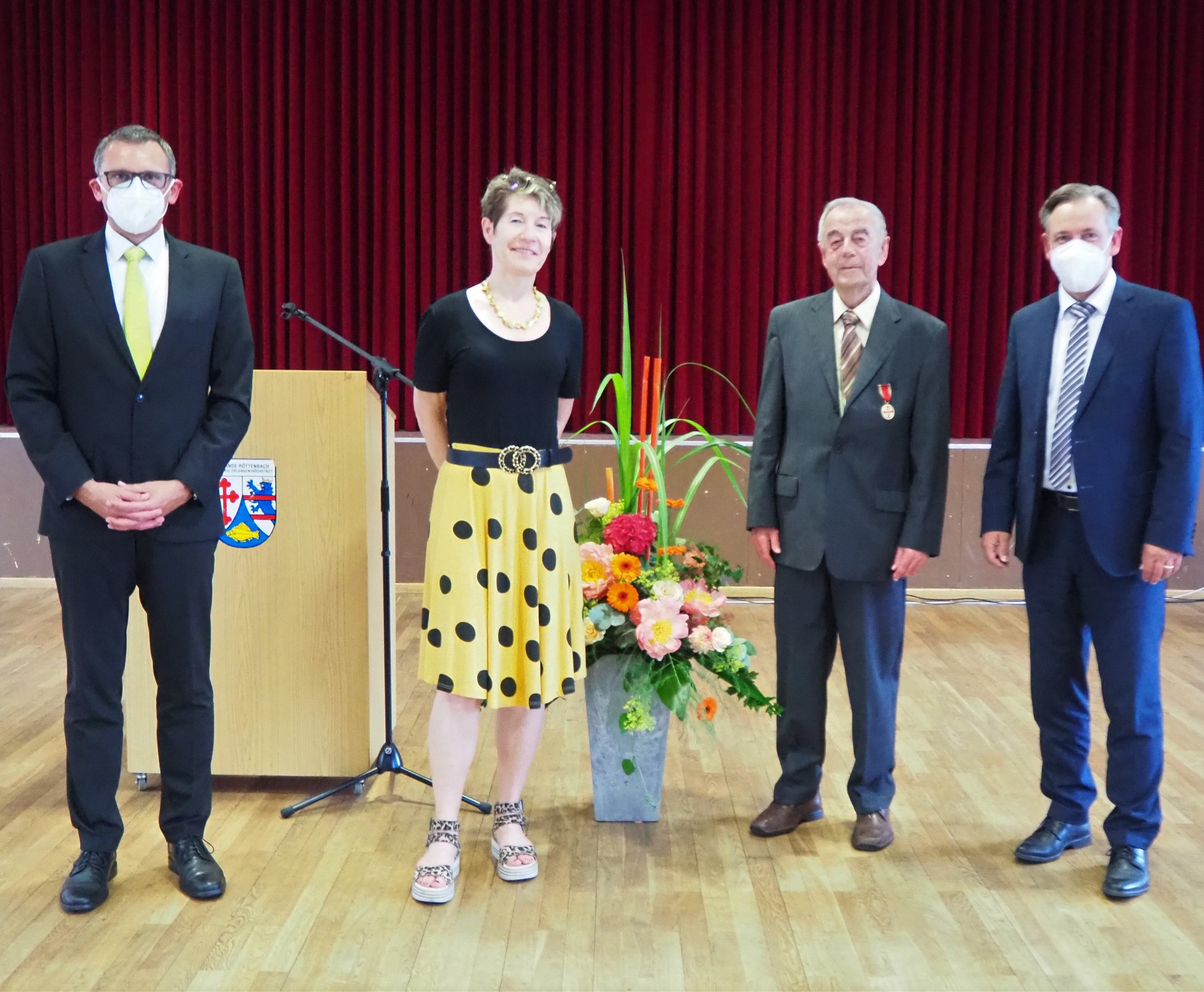 Der Geehrte Johann Müller strahlt mit Ehefrau Susanne. Landrat Alexander Tritthart (rechts) und Bürgermeister Ludwig Wahl (links) gratulieren.